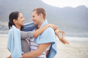 Image showing Happy couple, man and woman on beach with blanket hugging, love and romance in relationship. People, dating and joyful on vacation for holiday, travel and adventure on ocean or sea and mountain view