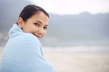 Image showing Woman, towel and ocean with portrait, smile and sand for relax and rest in cape town. Tourist, beach and sea for travel, adventure and holiday with blanket for comfort and positivity in nature