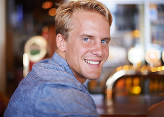 Image showing Portrait, smile and a man at cafe to relax, cheerful and positive facial expression for leisure at restaurant in Australia with bokeh. Face, cafeteria and happy person or customer in casual clothes