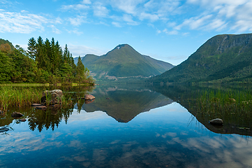 Image showing Serene lake at dawn with reflection of surrounding mountain and 