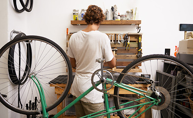 Image showing Mechanic, bicycle and garage with tools to service for maintenance, fixing and startup business. Back view, workshop and bike at work with instruments as expert with career to check and repair