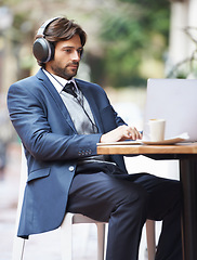 Image showing Businessman, laptop and headphone working in cafe, internet and social media for online meeting and remote work. Professional, technology and lunch break with coffee and google it for networking idea