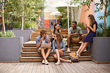 Image showing Students, talking and laptop or relax on break, campus and browse on social media for update. People, diversity and technology at university for online research and cellphone to scroll or networking