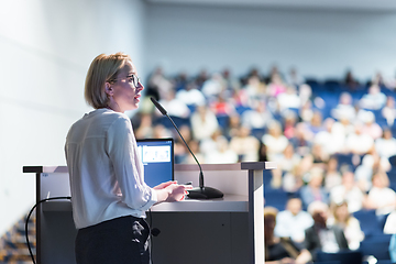 Image showing Female speaker giving a talk on corporate business conference. Unrecognizable people in audience at conference hall. Business and Entrepreneurship event.