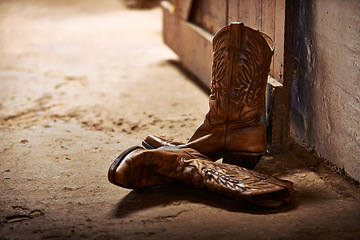 Image showing Cowboy boots, ranch and style at farm for walking, safety and retro fashion on floor, ground and barn. Shoes, leather product and vintage heel with pattern for steps, western aesthetic or culture