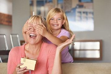 Image showing Mothers day, excited and daughter with surprise, sofa and smile in house while closing eyes and gift. Mom, kid and present on couch, home and happy for birthday or playing peekaboo for love and fun