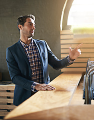 Image showing Businessman, table and order drink in bar after long day at work, relax and pub counter for wine. Male person, buying and beer for leisure after job for happy hour, call and hand sign for waiter