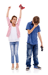 Image showing Children, siblings and winner with loser for gaming competition or esports on a white studio background. Boy and girl with smile, controller and disappointment for victory or loss on console games