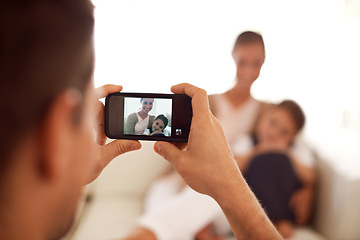 Image showing Father taking a picture of family, home and screen with smartphone and social media in a lounge. Parents, mother and dad with daughter or child with memory and mobile user with digital app or network