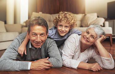 Image showing Floor, smile and grandparents with grandson in living room, together and love with happiness. Old people, grandmother and grandpa in house as seniors in retirement, elderly and bonding with boy