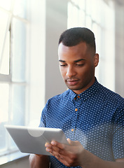 Image showing Businessman, tablet and reading at window for communication, internet search or networking in office. Entrepreneur, african employee or serious with technology for startup email or planning at work