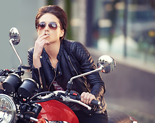 Image showing Motorcycle, leather and biker in city with cigarette for travel, or road trip as rebel. Fashion, street and woman smoker with attitude on classic or vintage bike for transportation or journey