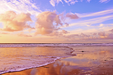 Image showing Ocean, sunset and sand with waves on tropical island and tourism destination for summer vacation in nature. Blue sky, clouds or neon color on torrey pines beach, foam or outdoor travel in california