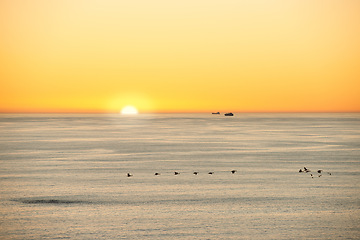 Image showing Ocean, sunset or sunrise in morning on island or birds flying on seascape for summer migration in nature. Golden sky, clear or ship on water to travel in marine industry for calm on natural landscape