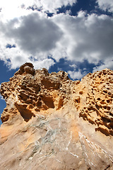 Image showing Mountain, rocks and natural landscape with cloudy sky, summer and sunshine on peak at travel location. Nature, cliff and sustainable environment with earth, stone and tropical holiday in low angle