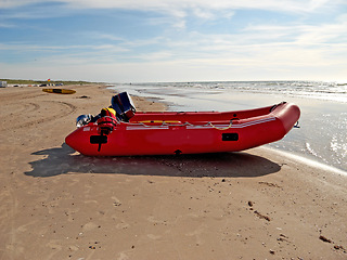 Image showing Beach, outdoor and inflatable boat on sand in nature by sea for travel in summer. Dinghy, transport and vessel on landscape, seashore or dock at harbor for sailing on journey by ocean in Australia