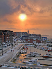 Image showing Sun, city and harbor with top view of street, buildings and boat in ocean for travel with people walking on path. Adventure, tourism and destination with transport, urban road and outdoor in Norway