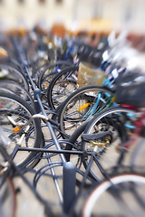 Image showing Bike rack, blur and travel in city, eco friendly and carbon footprint with closeup of transportation outdoor. Bicycle park, cycling and background for sustainable journey, environment and commute