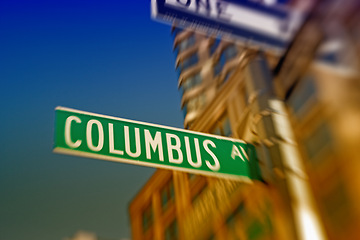 Image showing Street sign, pole and city with building for travel location for navigation, directions or New York. Road, architecture and holiday adventure in America for exploring or blurred, downtown or urban