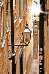 Image showing Alley, lantern and old town building for travel or cobble stone city for destination holiday, vacation or explore. Light, road and infrastructure in Italy for European trip, summer or sightseeing