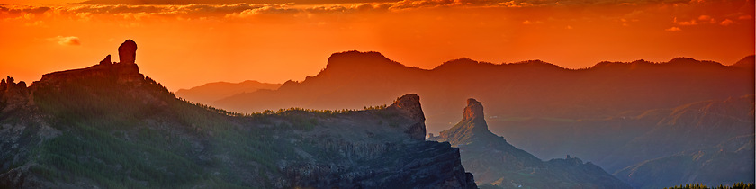 Image showing Landscape, sunset and panorama view of mountains, Gran Canaria Island with nature skyline and environment. Orange sky, horizon and natural background with travel location or destination in Spain