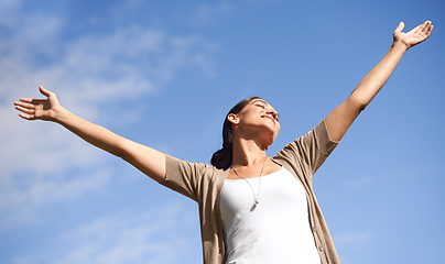 Image showing Smile, freedom and blue sky in summer with woman hands raised outdoor in fresh air of nature. Environment, happy or relax and young person satisfied with travel, vacation or holiday from below