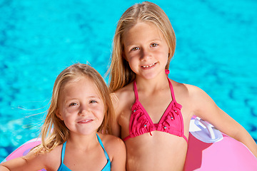 Image showing Summer, portrait and kids with inflatables at swimming pool for adventure at resort on vacation. Holiday, games or friends relax together with toys for fun in water, activity or children with fashion