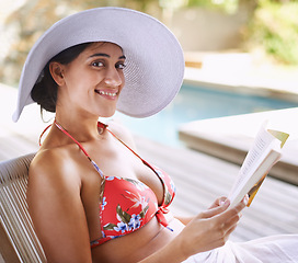 Image showing Woman, relax and outdoor with book by poolside for reading on holiday or getaway on weekend in summer. Happy and tanned person with smile and novel bikini for swim and vacation for travel and rest