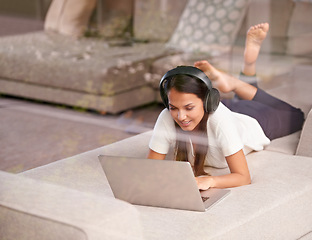Image showing Woman, headphones and laptop for remote work, sofa and lounge to connect to window and tech smile. Female person, entertainment and couch in living room, working from home and online for network