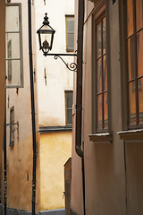 Image showing Travel, alley and lamp on vintage building in old town with history, culture or holiday destination in Sweden. Vacation, architecture and antique lantern in Stockholm with retro light in ancient city