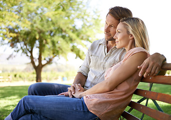 Image showing Couple, happiness and bench in park with love on honeymoon date, bonding and anniversary vacation. Holding hands, man and woman with smile outdoor for relax, healthy relationship and summer holiday