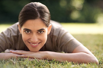 Image showing Portrait, Indian woman and lying on grass with smile at park for joy, refresh and relax with me time. Female person, bokeh and happy for leisure with break for rest, peace and quiet with wellbeing