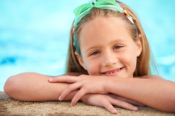 Image showing Girl, relax and portrait of child in swimming pool with goggles for games outdoor on holiday or vacation. Kid, smile and rest on hands at poolside and happy in water at resort or house in summer