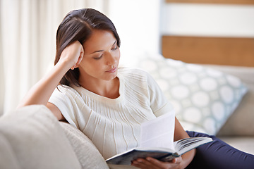 Image showing Woman, sofa and reading with book in relax for story, literature or leisure in living room at home. Female person sitting on couch with novel for knowledge, education or learning in lounge at house