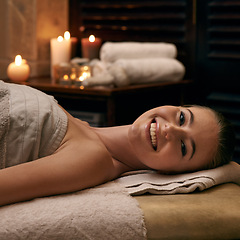 Image showing Happy, woman and portrait on table in spa with candles at night for luxury treatment in hotel on vacation. Girl, relax and smile for cosmetics, skincare and holiday at resort for beauty and wellness