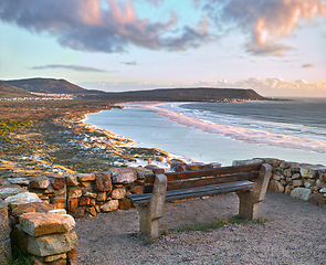 Image showing Water, view and beach sunset with peace, beauty and location tranquility in nature. Sea bench, freedom and ocean sunrise for summer, travel or vacation, holiday or stress relief in South Africa