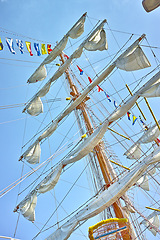 Image showing Sailing, ship and mast outdoor with flag for travel, journey and low angle of blue sky in summer. Boat, wood pole and vintage schooner vessel on a cruise, rigging and transport in nature with rope