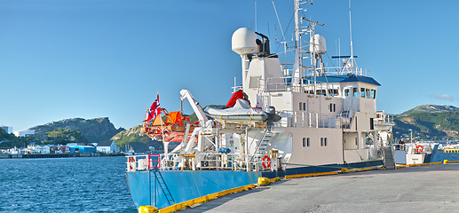 Image showing Ship, water and harbor at sea to coast guard with landscape, blue sky and transportation for emergency sailing. Vessel, dock and ocean with yacht for maritime, danger and patrol in morning and nature