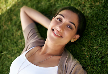 Image showing Portrait, smile and relax with woman on grass outdoor in summer from above to enjoy fresh air. Face, nature and wellness with happy young person lying in field at park or garden for weekend break