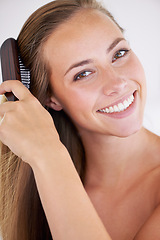 Image showing Portrait, brush or hair care of happy woman in bathroom in home for cosmetics, clean or wellness for healthy growth. Hairstyle, face or person combing for morning routine, beauty or keratin treatment