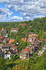 Image showing Houses, trees in village or countryside landscape, travel and adventure location with hill, nature and buildings. Neighborhood, real estate and property with architecture for holiday in Germany