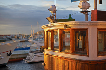 Image showing Boat, water and harbor at sea to travel with closeup, windows and transportation for vacation sailing. Ship, dock and ocean with yacht for tourism, holiday and adventure with sunset, sky and nature