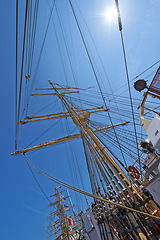 Image showing Sailing, boat and mast outdoor with flag for travel, journey and low angle of blue sky in summer. Ship, wood pole and vintage schooner vessel on a cruise, rigging and transport in nature with rope