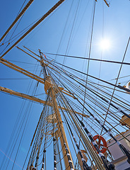 Image showing Sailing, ship and mast outdoor with rope for travel, journey and low angle of blue sky in summer. Boat, wood pole and vintage schooner vessel on a cruise, rigging and transportation with sunshine