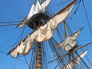 Image showing Sailing, boat and mast outdoor with rope for travel, journey and adventure by blue sky in summer in the morning. Ship, wood pole and vintage schooner vessel on a cruise, rigging and transportation