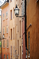 Image showing Travel, architecture and lamp in vintage alley of old town with history, culture or holiday destination in Sweden. Vacation, buildings and antique lantern in Stockholm with retro light ancient city