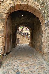 Image showing Arch, path and brick wall with tunnel of ancient passageway, building pattern or exterior architecture. Empty route, concrete trail or historic landmark of secret hallway or hidden outdoor corridor