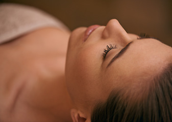 Image showing Woman, lying and relax in spa for luxury or peace, massage therapy or skincare and calm to free tension. Female person, closeup and wellness for stress relief or rest for wellbeing with aromatherapy.