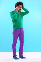 Image showing Fashion, black man and studio in phone call with colorful clothes in blue background for trendy, style and outfit. Male person, stylist and fashionable for trends with smile, funky and edgy.