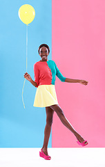 Image showing Woman, balloon and smile with colorful clothes for fashion, trendy and playful for outstanding and bold style. African person, model and happy lady for funky look, retro or different for fun